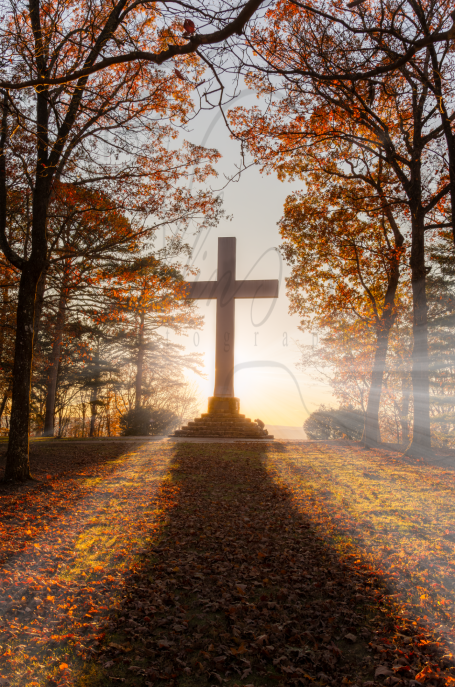 Man Kneeling at Majestic Mountain Cross